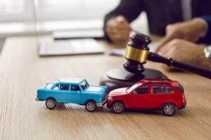 little crashed autos on table in courtroom